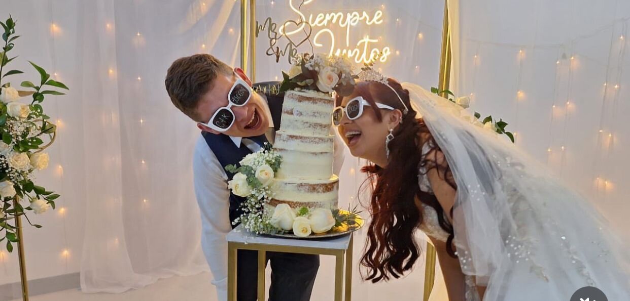 Karen y Christian - Pareja de novios posando con su torta de boda
